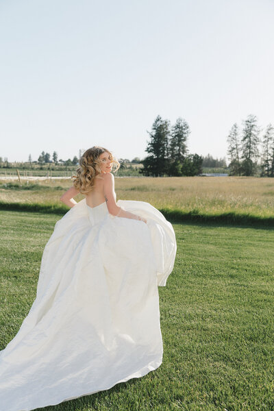 Styled shoot in Spokane, WA. Bride in wedding dress looking over her shoulder and running away