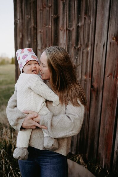 Mamma håller sin dotter i famnen och gosar in näsan mot dotterns kind.