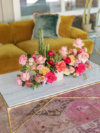 Modern floral centerpiece with cactus and colorful blooms styled for creative Austin event decor in a chic lounge setting.