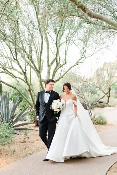 Bride and Groom walking down a path outside at the Four Seasons at Troon North in Scottsdale
