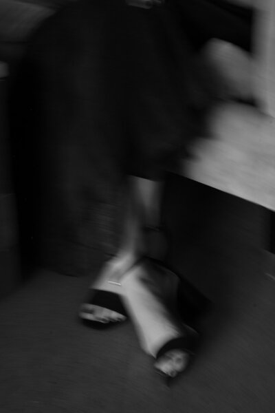 Blurry black and white photo of woman's dress and heels