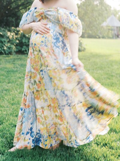 A blurry view of a mom swaying her colorful dress, photographed by DC maternity photographer, Marie Elizabeth Photography.