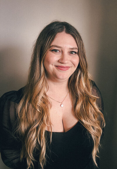 Portrait of Denise Horwedel, junior designer at ReDesign, sitting on a chair with a warm smile.