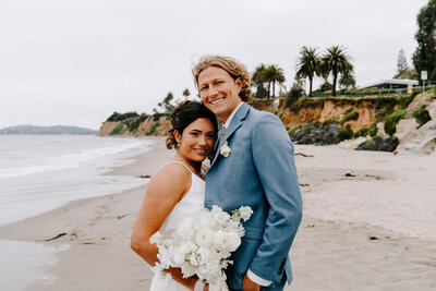 newlyweds smiling on beach