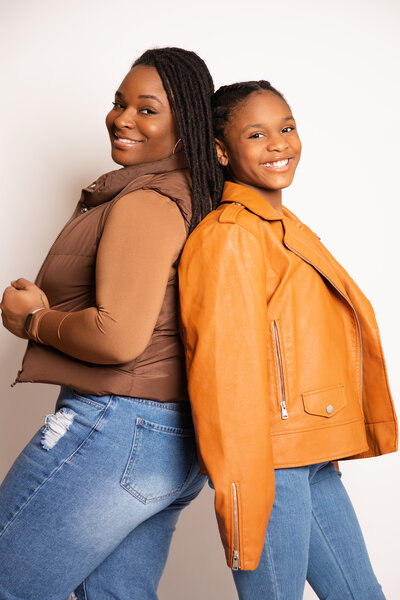 Mother & daughter posing back to back.