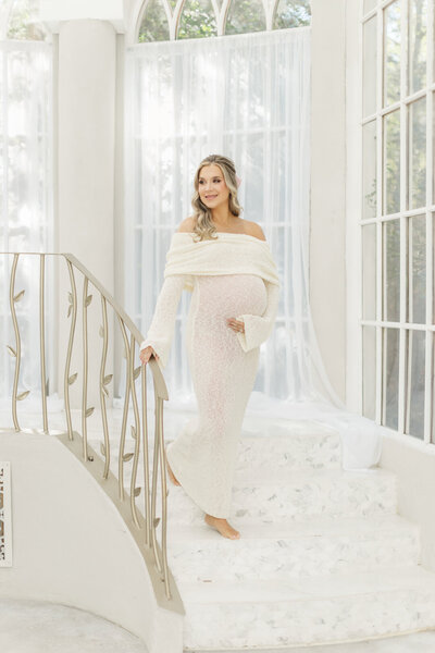 pregnant mom descends stair case in conroe studio