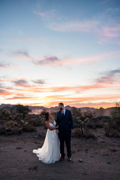 Bride and groom at sunrise in the superstition mountains.