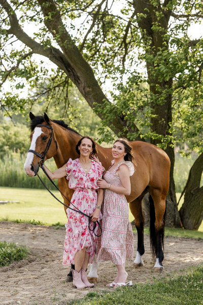 Mother and daughter pose with their horse during golden hour family portrait session