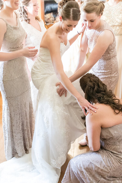 Bridesmaids helping bride get ready