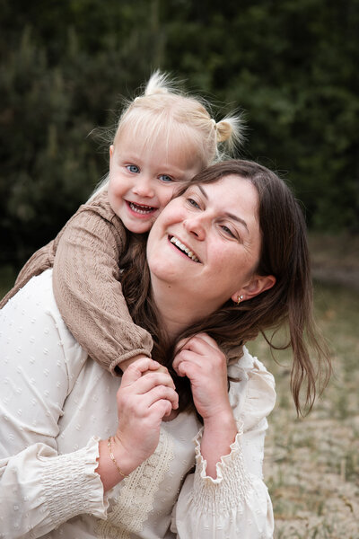 Een vader gooit zijn tweejarige zoontje in de lucht tijdens een ongedwongen gezinsshoot.