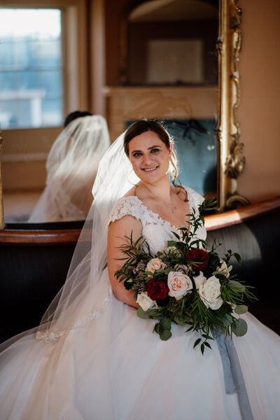 Bride holding her bouquet wearing veil