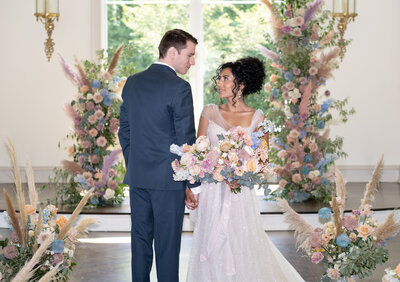 Bride and groom are surrounded by flowers inside a chapel in New Jersey.