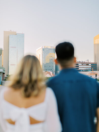 couple facing away from the camera looking at the city view