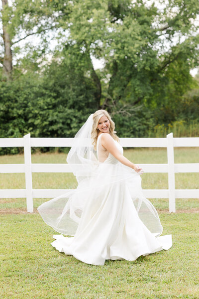 A young bride twirls happily in her elegant wedding dress