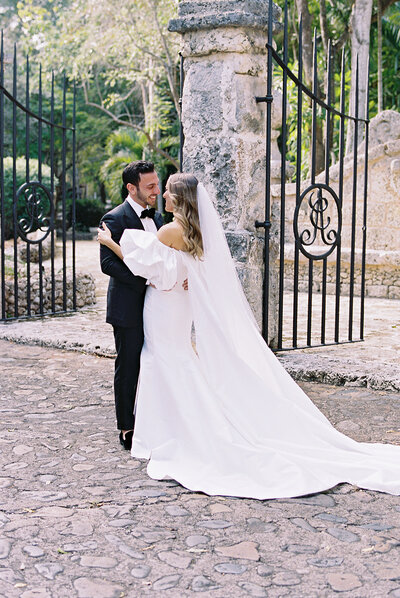 Bride and groom sharing an intimate embrace in the cobblestone courtyard of Altos de Chavón — timeless destination wedding portrait captured by Asia Pimentel Photography.