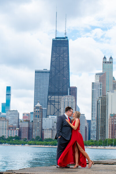 Man and his fiance pose for engagement photo in front of city skyline
