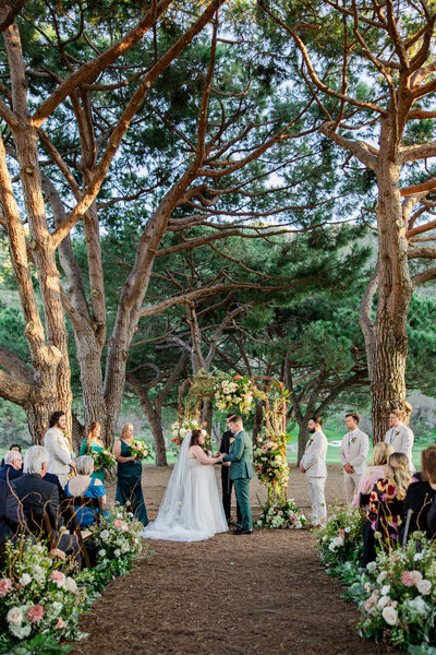 bride and groom at ceremony under the trees
