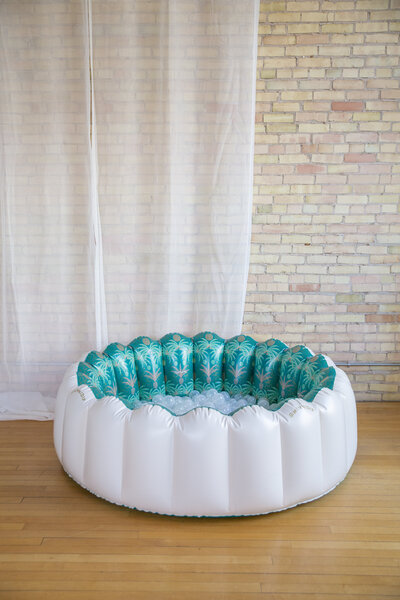 A white and green scalloped ball pool with clear balls inside.
