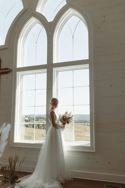 Bride and groom portraits on top of convertable white car kissing forehead