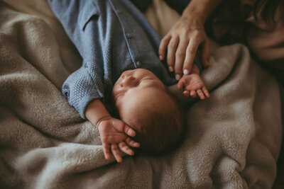 mom snuggles little newborn