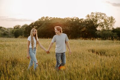 man and woman holding hands in a field