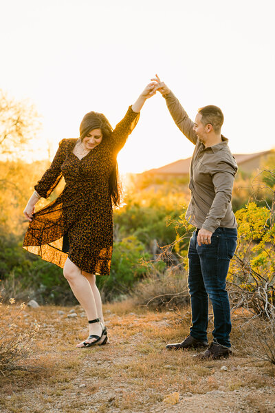 LGBTQ+ lesbian couple kissing under a saguaro for their  desert engagement photoshoot session in Cave Creek Arizona .