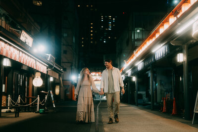 Natalie Dyer, founder of Natalie Dyer Photo, and her husband walking through the vibrant streets of Tokyo, Japan, experiencing the city's dynamic energy