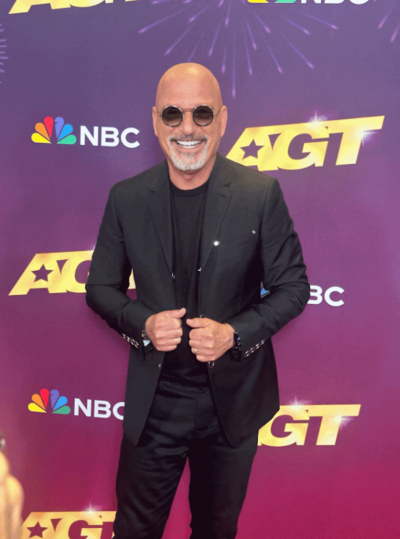 Photo of Howie Mandel against a step and repeat for America's Got Talent