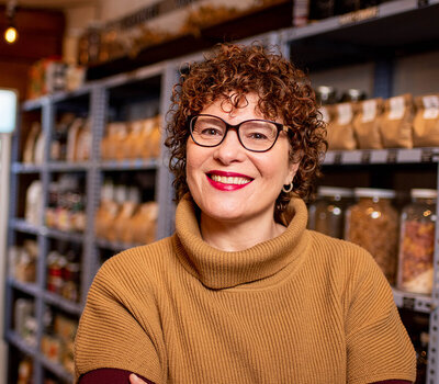 A woman smiles in her headshot photo in the callicoon pantry store