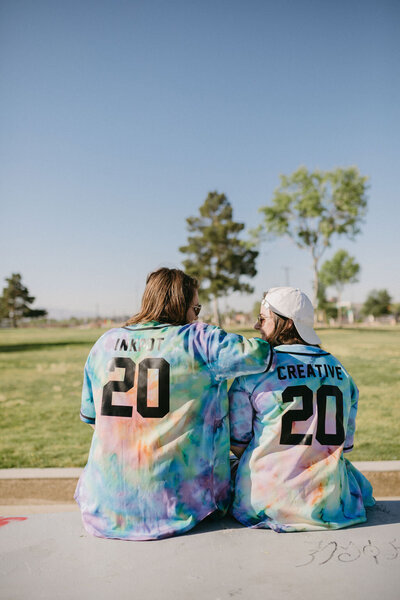 Two girls sitting in jerseys that say Inkpot Creative.