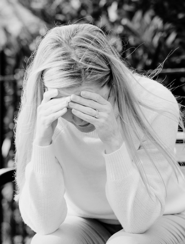 Black and white photo of woman sitting alone crying