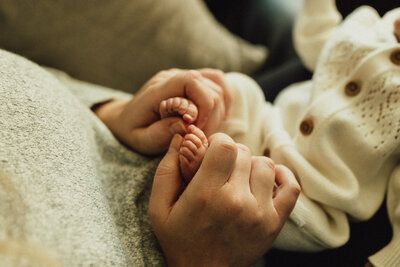 Newborn baby girl swaddled in blush pink wrap on rounds cushion - luxury newborn photography in Maple Grove Minnesota