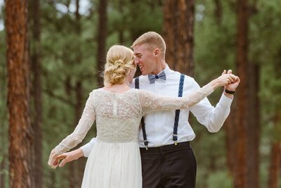 An elopement couple dances in the woods