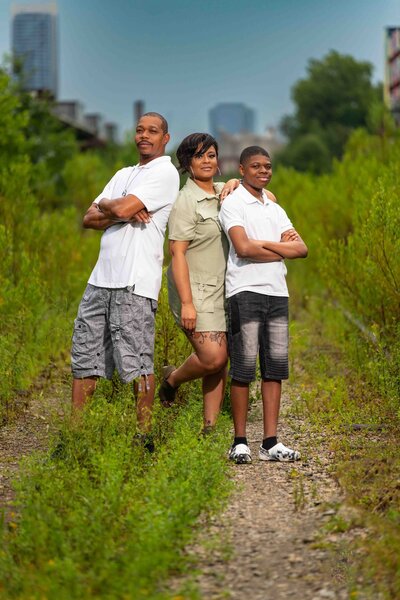 Family of 3 posing in grassy area