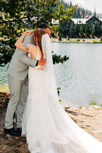 Bride and groom embrace during first look at Lake Levinsky