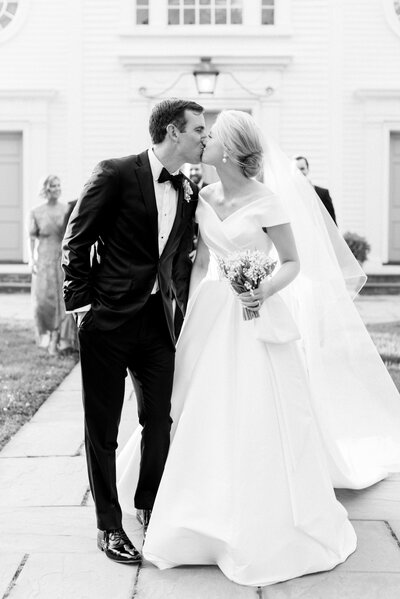 bride and groom kissing outside of church