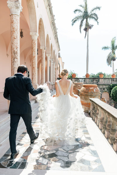 groom holding brides dress by sarasota wedding photographer