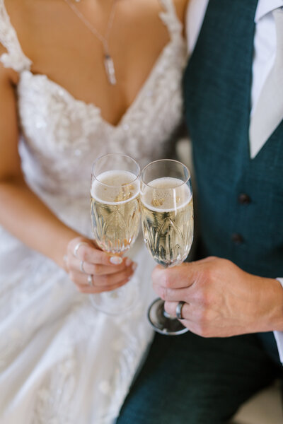 Bride and groom hold champagne