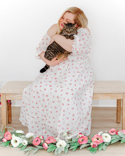 woman snuggling a tabby cat in her arms in a photo session