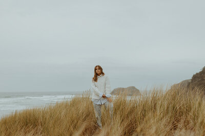 girl standing next to beach at the oregon coast