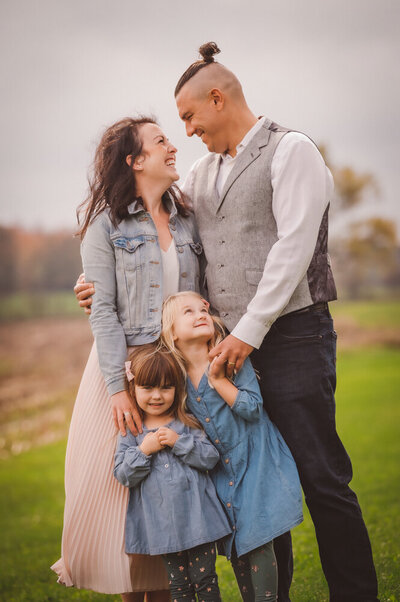 family portrait in field with two little girls in denim