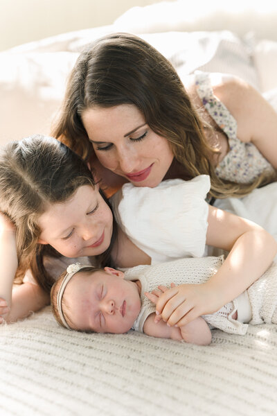 A mom snuggles her nursing toddler on her lap and is smiling down at him.