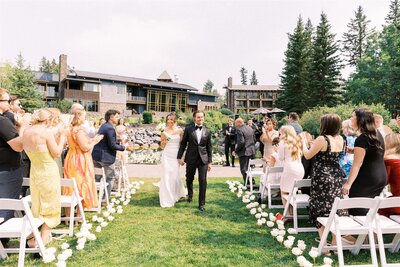 Couple walking down the aisle after saying I do outside on the grounds of Azuridge Estate Hotel in Calgary
