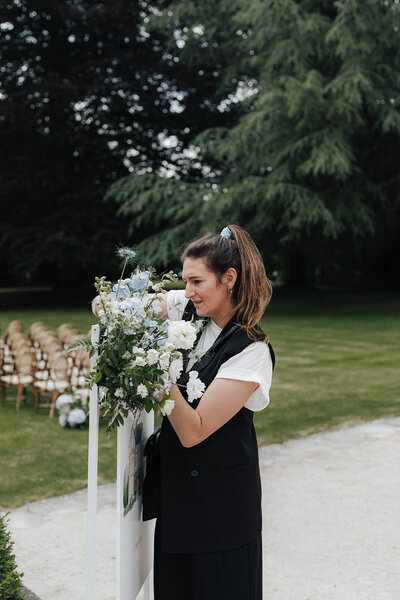 Nele D'hoe die bloemen voor een trouw herschikt van de ceremonie aan het welkomstbord