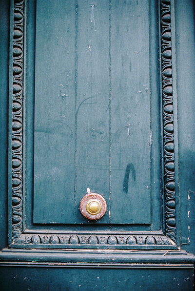 film photograph of blue door and bronzed door knob in Paris France