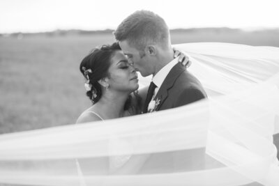 black and white photo of couple about to kiss in field