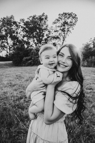 Motherhood moment with mom holding baby tightly, both smiling