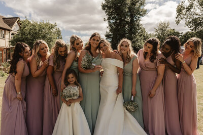 bridesmaids and bride standing in a line and smiling