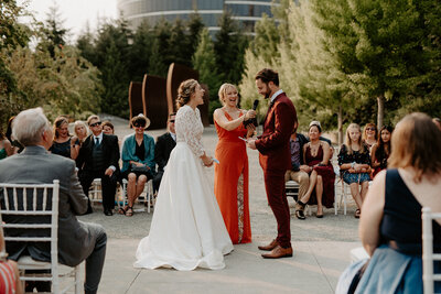 A joyous couple exchanges vows during their ceremony at Olympic Sculpture Park, surrounded by friends and family.