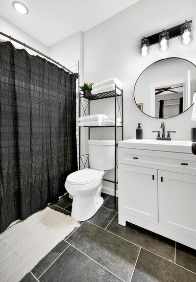 Bathroom with beautiful vanity in this three-bedroom, two-bathroom home with fully stocked kitchen, large backyard, grill, and basketball hoop in downtown Waco, TX.